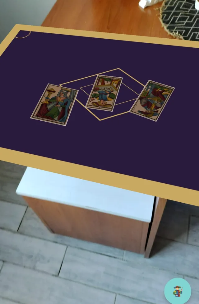El paño de Bateleur anclado en realidad aumentada sobre un mueble real, con tres cartas del Tarot Lequart dadas vuelta encima.